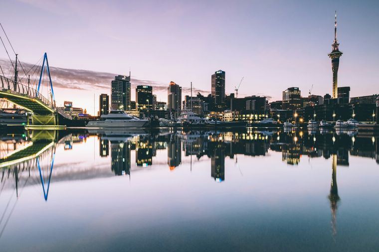 Auckland skyline and the Sky Tower reflected in the Viaduct Harbour at dusk